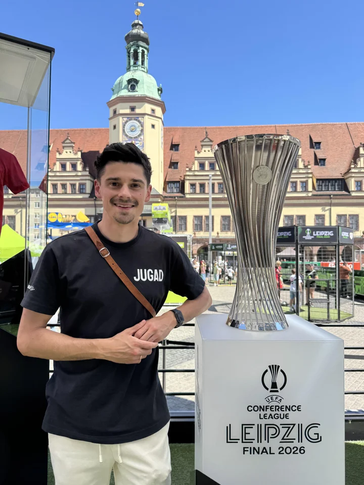 Julian im JUGAD-Shirt neben einem ausgestellten Fußballpokal.